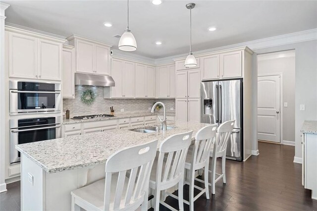 2385 Saddle Brook Trce, Cumming, GA 30040 - kitchen featuring stainless steel appliances, under cabinet range hood, a sink, crown molding, and baseboards