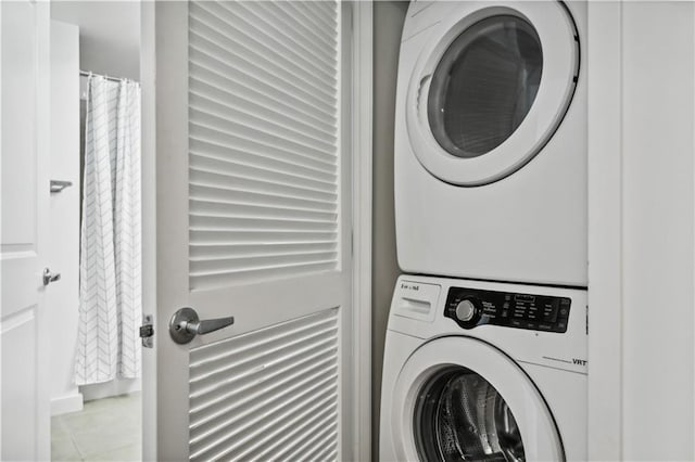 clothes washing area with stacked washing maching and dryer and light tile patterned floors