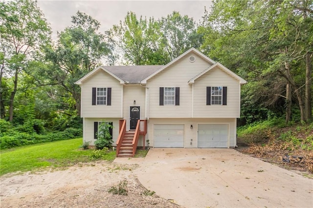 5069 Jonesboro Rd, Union City, GA 30291 - bi-level home featuring a garage, concrete driveway, and view of wooded area