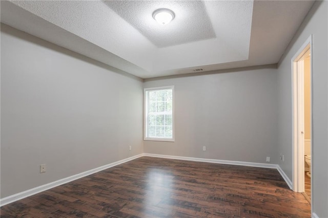 5069 Jonesboro Rd, Union City, GA 30291 - spare room with a raised ceiling, dark wood finished floors, and a textured ceiling