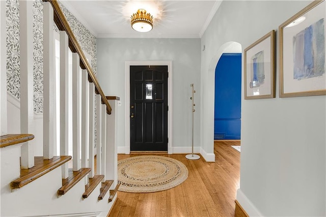 foyer entrance featuring hardwood / wood-style flooring and crown molding