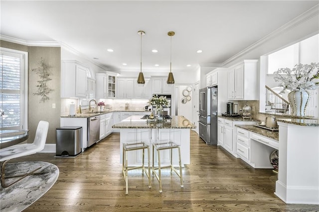 kitchen with appliances with stainless steel finishes, stone counters, and white cabinets