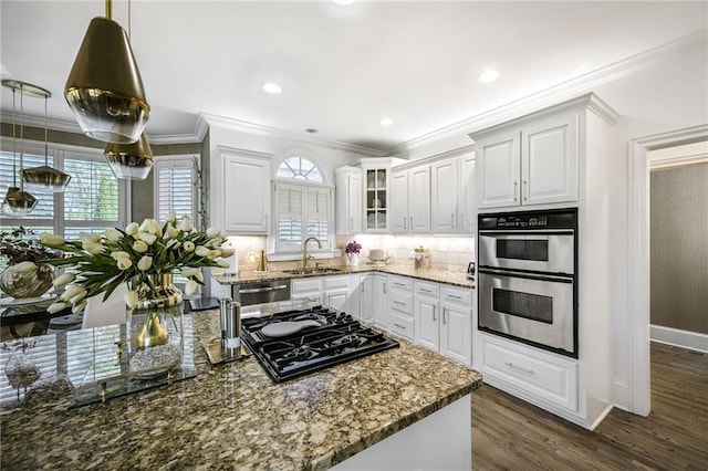 kitchen with stainless steel appliances, ornamental molding, stone countertops, and a sink