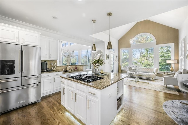 kitchen with black gas cooktop, high quality fridge, dark wood-style flooring, open floor plan, and light stone countertops