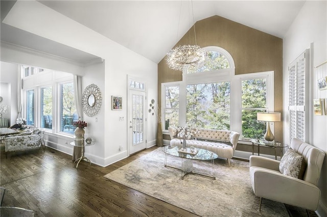 living room featuring high vaulted ceiling, an inviting chandelier, baseboards, and wood finished floors