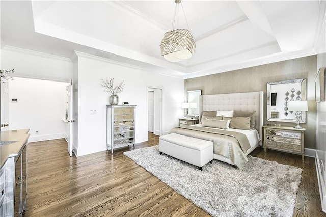 bedroom featuring crown molding, a raised ceiling, dark wood finished floors, and baseboards