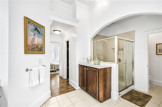 full bathroom with ornamental molding, tile patterned flooring, a shower stall, and toilet