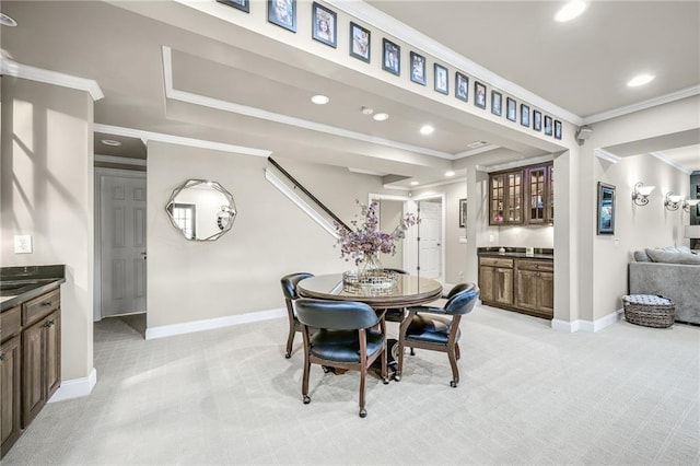 dining room featuring recessed lighting, light colored carpet, baseboards, ornamental molding, and wet bar