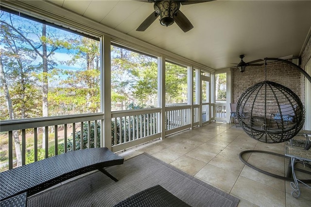 unfurnished sunroom featuring a ceiling fan