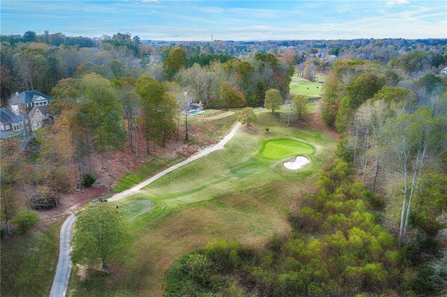 aerial view featuring view of golf course and a wooded view