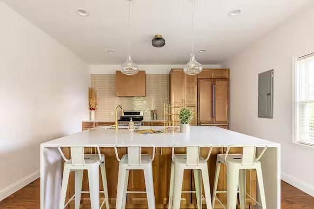 kitchen featuring decorative light fixtures, sink, a kitchen breakfast bar, electric panel, and a spacious island