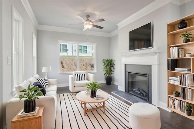 living room with dark hardwood / wood-style flooring, ornamental molding, and ceiling fan