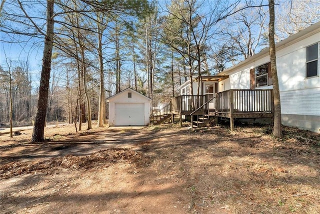 view of yard with a garage, an outdoor structure, and a deck