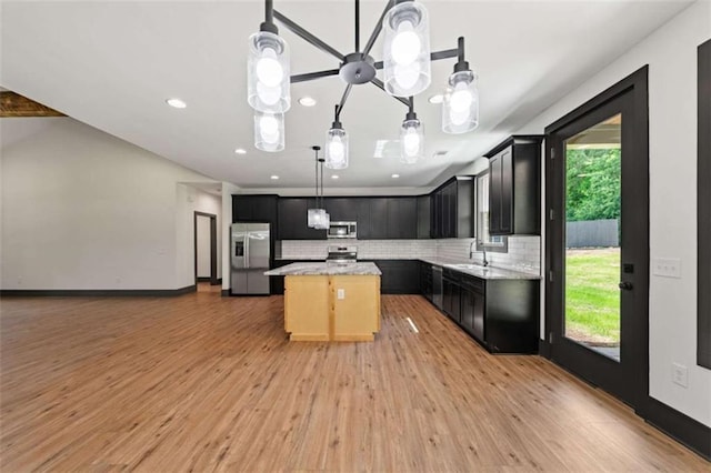 2462 New Hope Rd, Morganton, GA 30560 - kitchen with appliances with stainless steel finishes, a kitchen island, a sink, tasteful backsplash, and light wood-style flooring