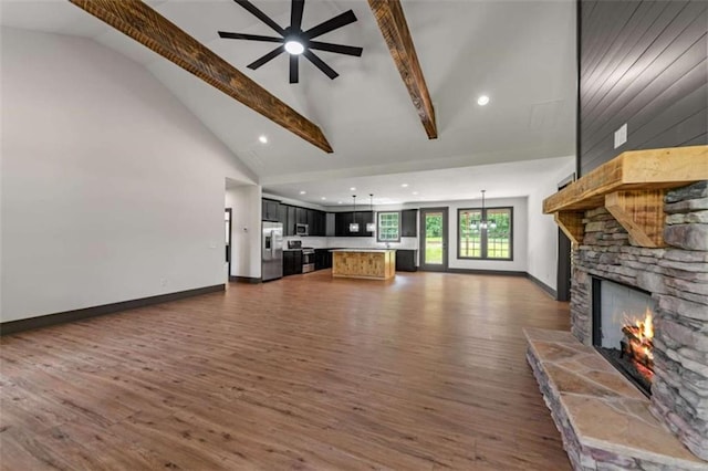 2462 New Hope Rd, Morganton, GA 30560 - unfurnished living room with a stone fireplace, high vaulted ceiling, beamed ceiling, dark wood finished floors, and baseboards