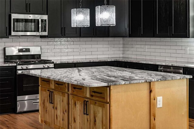 2462 New Hope Rd, Morganton, GA 30560 - kitchen with appliances with stainless steel finishes, a kitchen island, wood finished floors, and dark cabinetry