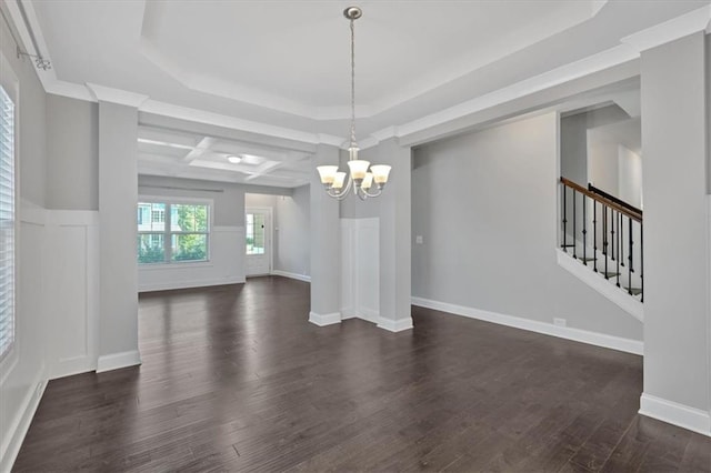 unfurnished dining area featuring dark wood-type flooring, a notable chandelier, and a tray ceiling