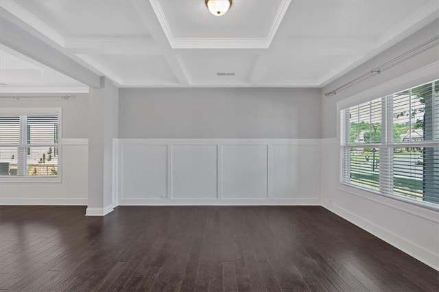 unfurnished room featuring coffered ceiling, beam ceiling, dark wood-type flooring, and a healthy amount of sunlight