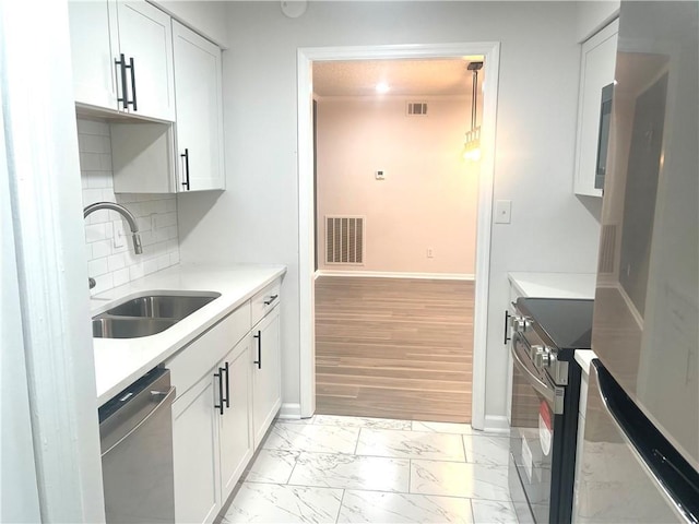 kitchen featuring visible vents, marble finish floor, a sink, white cabinetry, and dishwasher