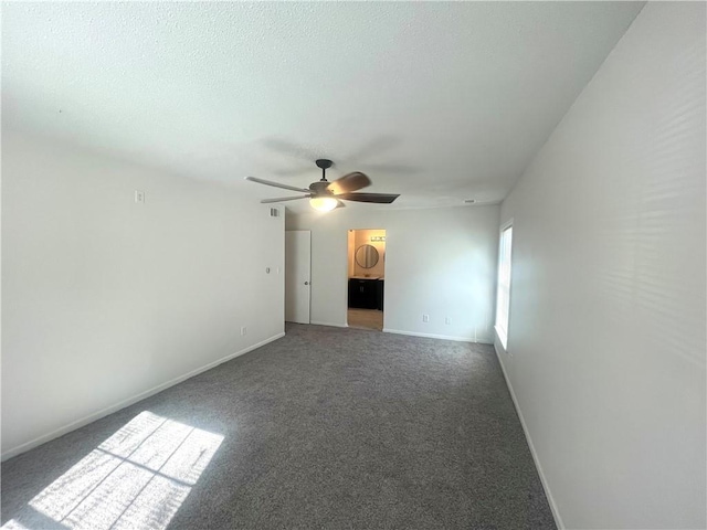 spare room featuring baseboards, carpet, ceiling fan, and a textured ceiling