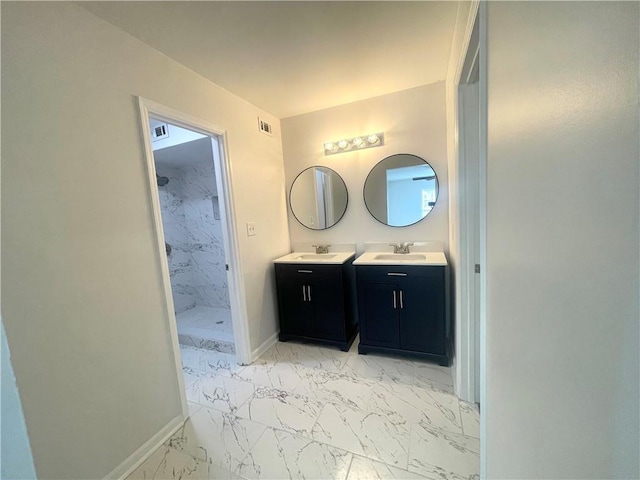 bathroom featuring baseboards, two vanities, a stall shower, marble finish floor, and a sink