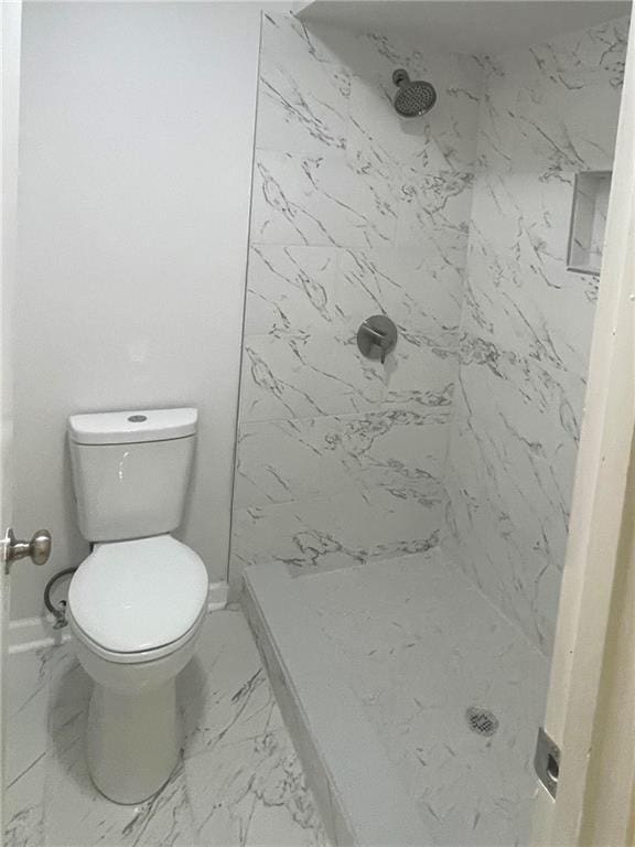 full bath featuring a marble finish shower, marble finish floor, and toilet