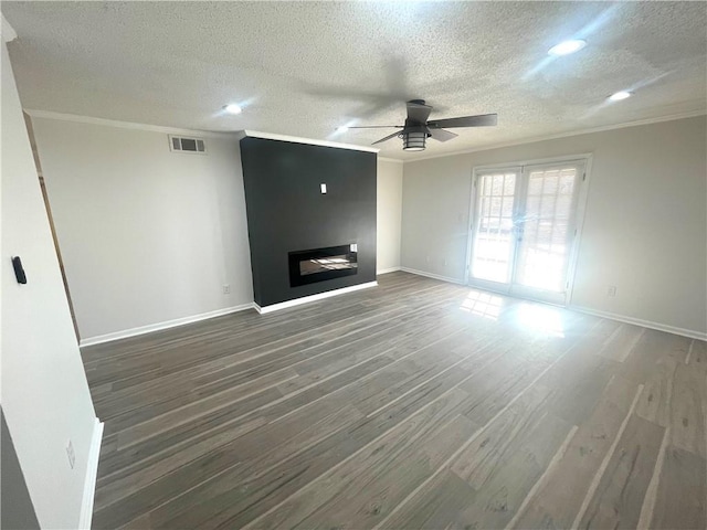 unfurnished living room featuring visible vents, wood finished floors, a ceiling fan, and ornamental molding