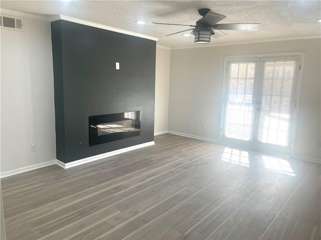 unfurnished living room with visible vents, a textured ceiling, wood finished floors, crown molding, and ceiling fan