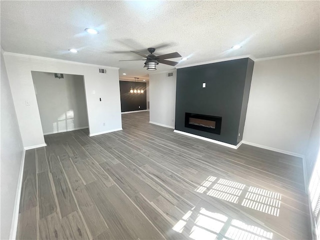 unfurnished living room featuring visible vents, ornamental molding, a ceiling fan, and wood finished floors