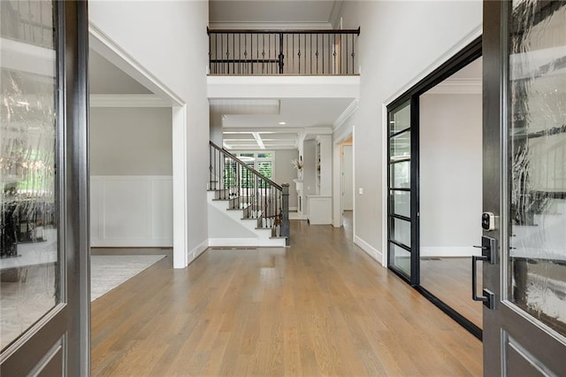 foyer entrance featuring crown molding and light hardwood / wood-style flooring