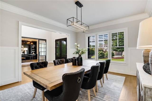 dining room featuring ornamental molding, a chandelier, and light wood-type flooring