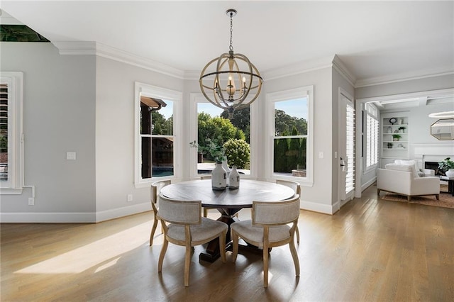 dining room featuring built in shelves, ornamental molding, a chandelier, and wood-type flooring