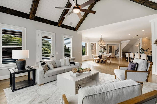 living room with light hardwood / wood-style flooring, beam ceiling, plenty of natural light, and high vaulted ceiling