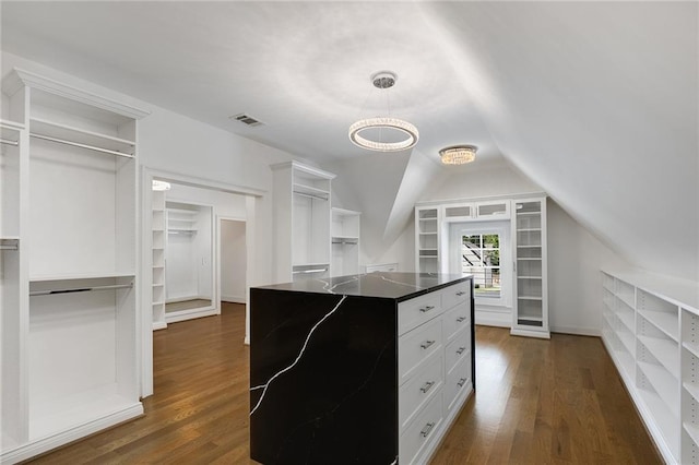 walk in closet with dark hardwood / wood-style flooring and lofted ceiling