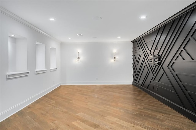 empty room with hardwood / wood-style flooring and crown molding