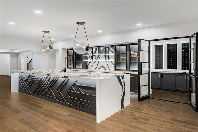 kitchen with a large island, dark hardwood / wood-style flooring, sink, and hanging light fixtures