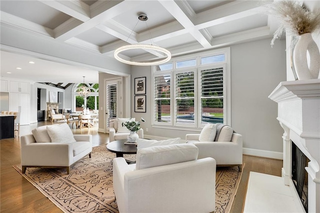 living room featuring beamed ceiling, plenty of natural light, coffered ceiling, and light hardwood / wood-style floors