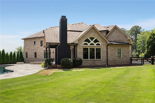 back of house with a lawn and a patio