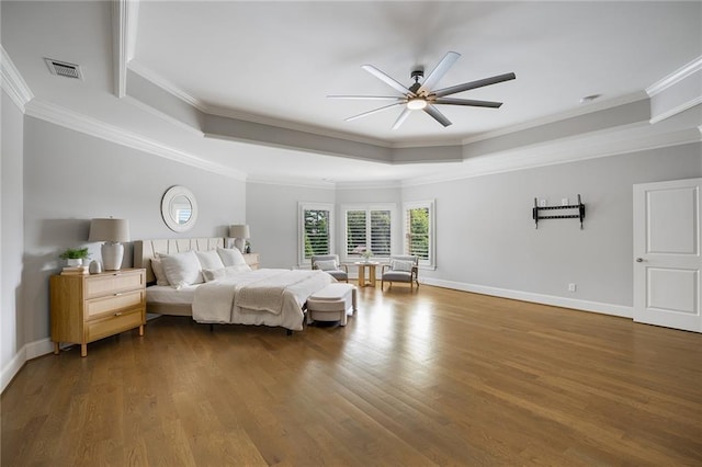 bedroom featuring hardwood / wood-style floors, crown molding, a raised ceiling, and ceiling fan