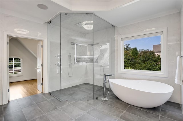 bathroom with shower with separate bathtub, vaulted ceiling, and tile patterned floors