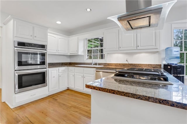 kitchen with white cabinetry, appliances with stainless steel finishes, sink, and dark stone countertops