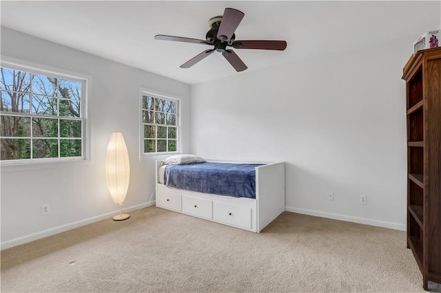 unfurnished bedroom with ceiling fan and light colored carpet