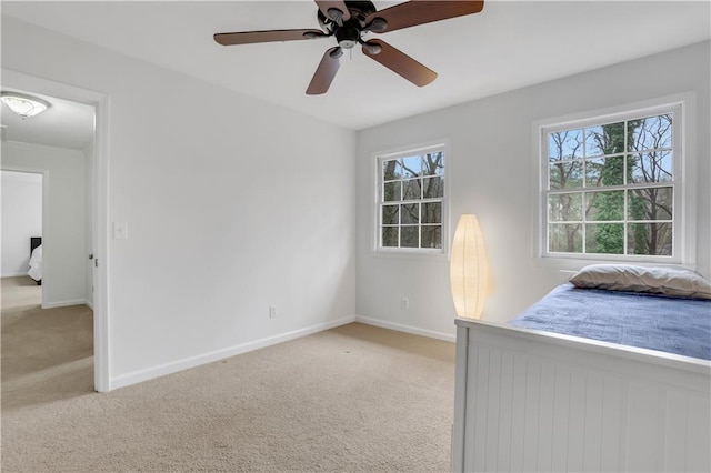 unfurnished bedroom with light carpet, multiple windows, and ceiling fan