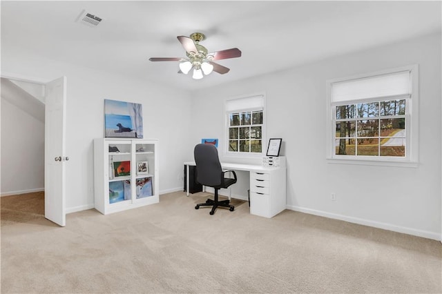 carpeted office with ceiling fan and plenty of natural light