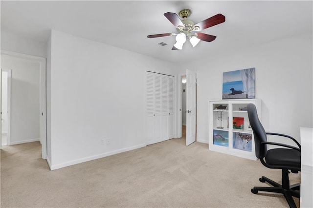 unfurnished office featuring light colored carpet and ceiling fan