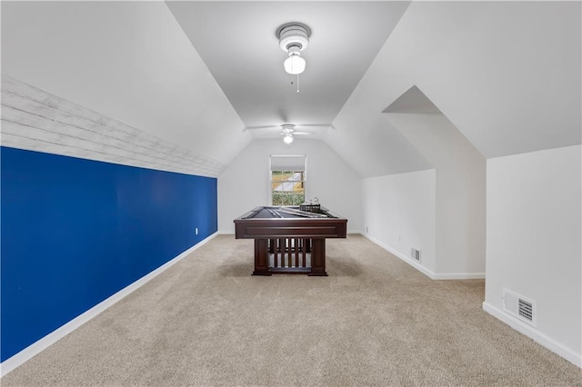 recreation room with vaulted ceiling, light colored carpet, and ceiling fan