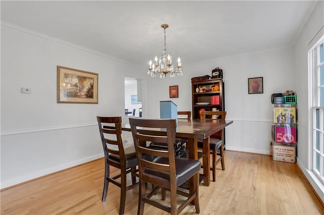 dining room with crown molding, an inviting chandelier, and light hardwood / wood-style floors