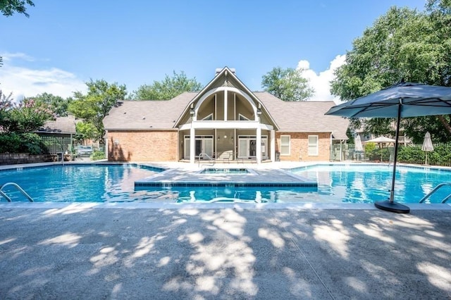 community pool with fence and a patio