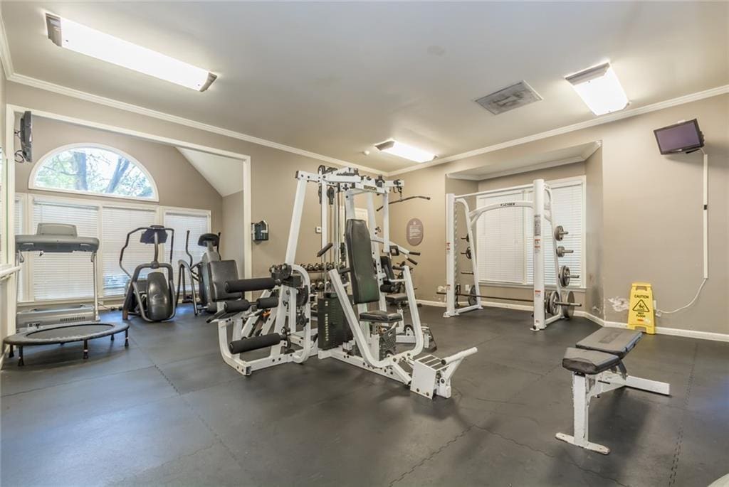 workout area featuring ornamental molding, visible vents, and baseboards