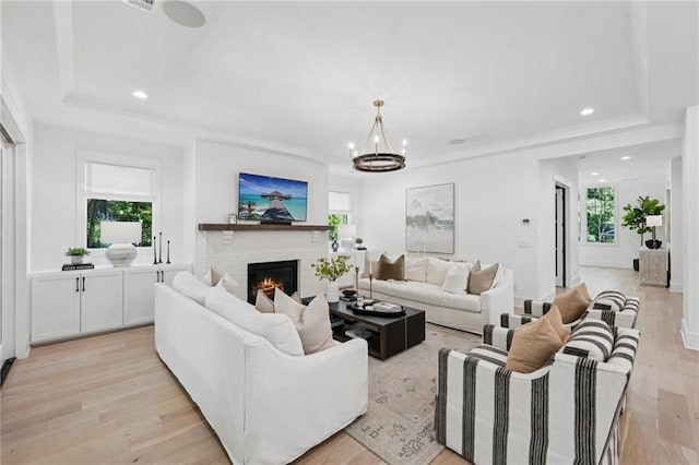 477 Michael Dr, Alpharetta, GA 30009 - living room featuring light wood finished floors, a brick fireplace, a chandelier, a raised ceiling, and recessed lighting